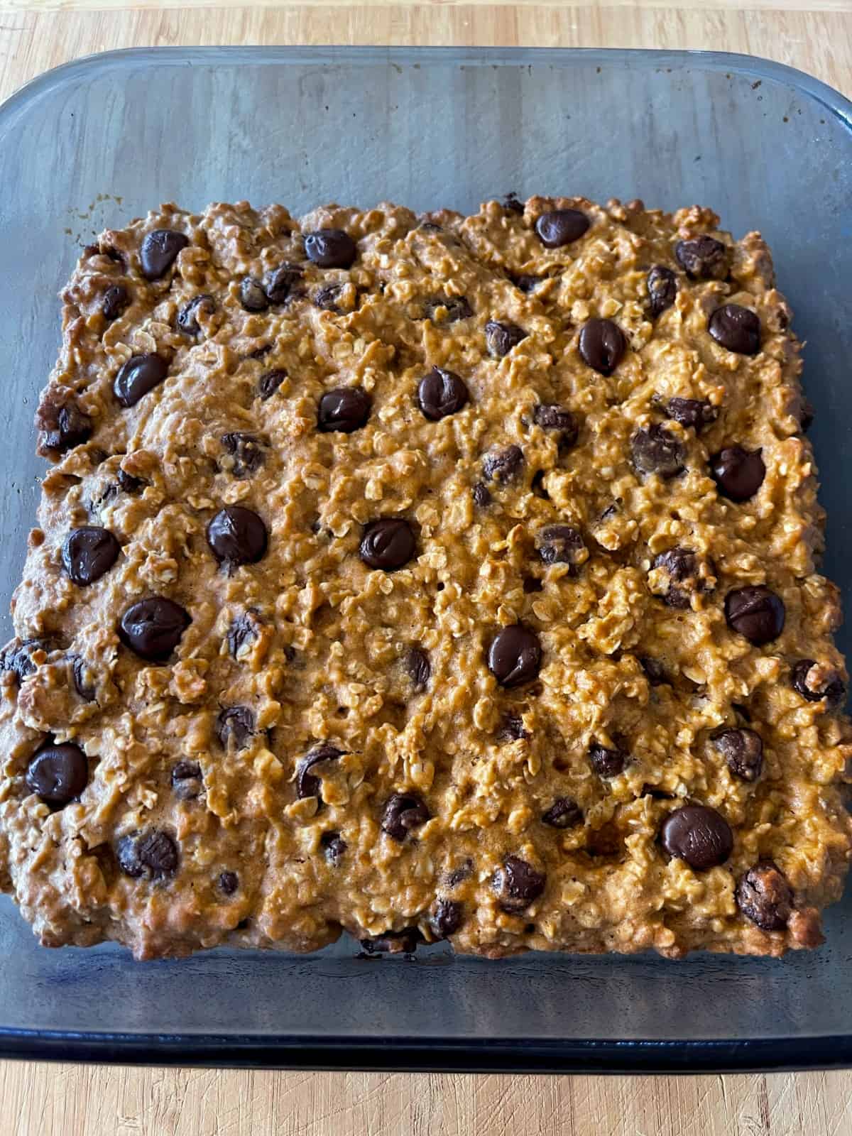 Fresh baked low fat Oatmeal Chocolate Chip Cookie Bars cooling in blue glass baking dish.