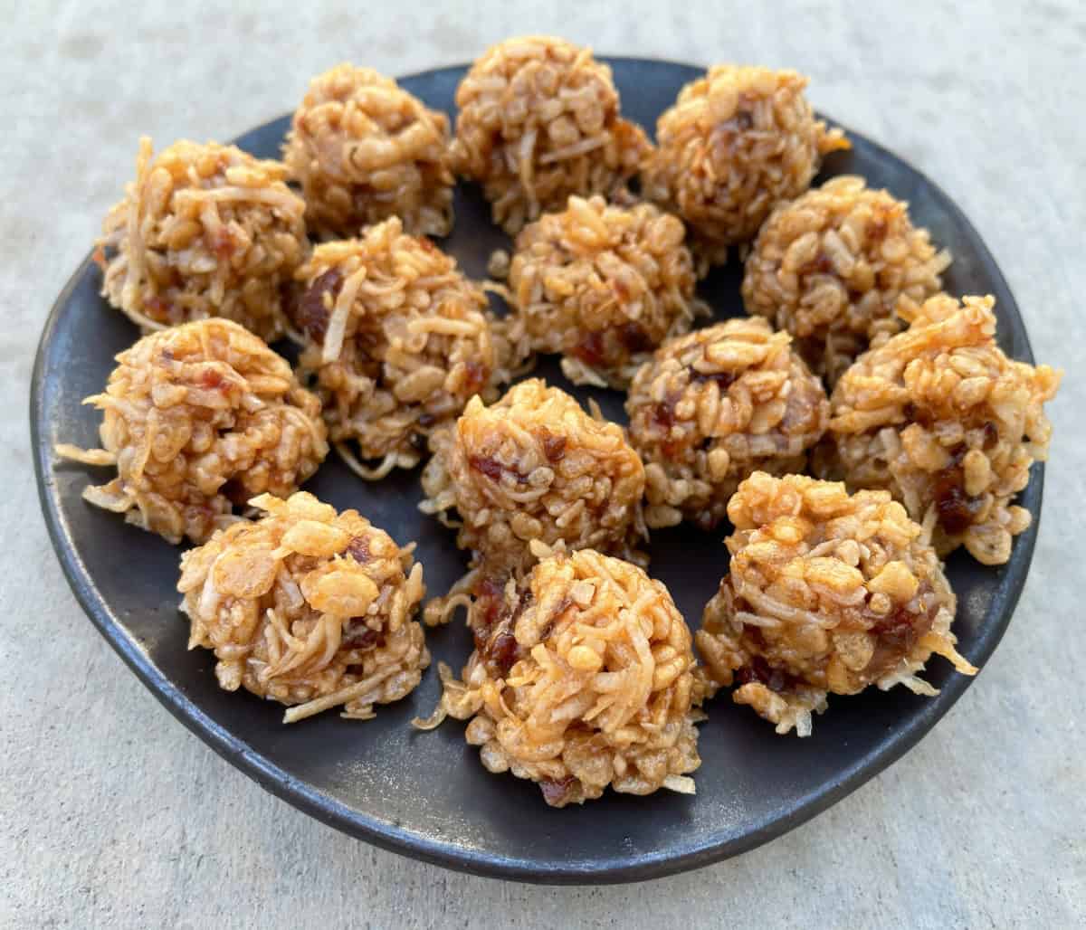 No Bake Rice Krispies Date Balls on brown ceramic serving plate.