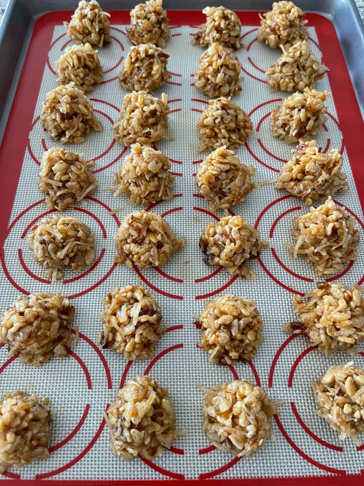 No Bake Rice Krispies Date Balls on silicone lined baking sheet pan.