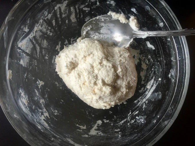 Ball of 2-ingredient dough in glass bowl with spoon.
