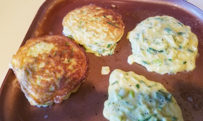 Cooking zucchini pancakes on skillet