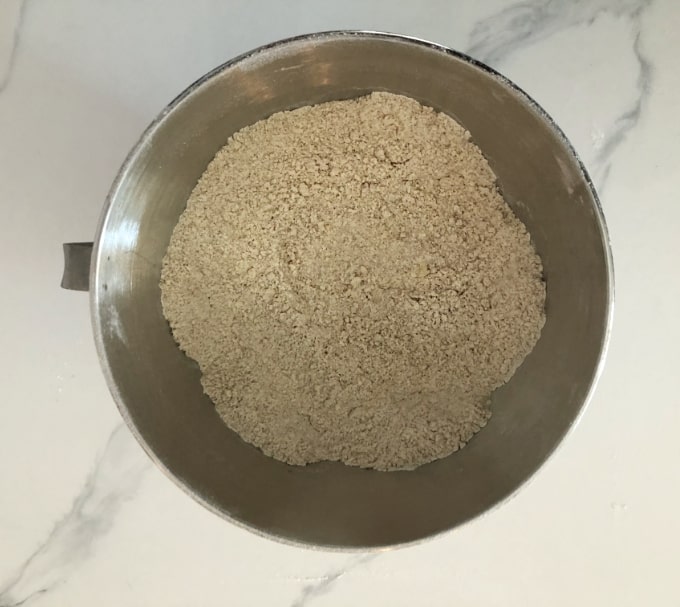 Healthy homemade Bisquick baking mix in stainless mixing bowl on white marble counter.