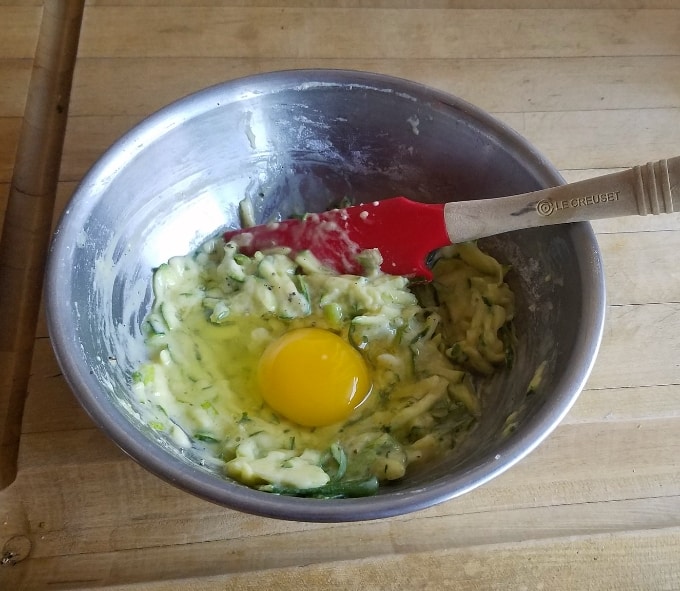Mixing shredded zucchini, eggs, baking mix and green onions in mixing bowl.