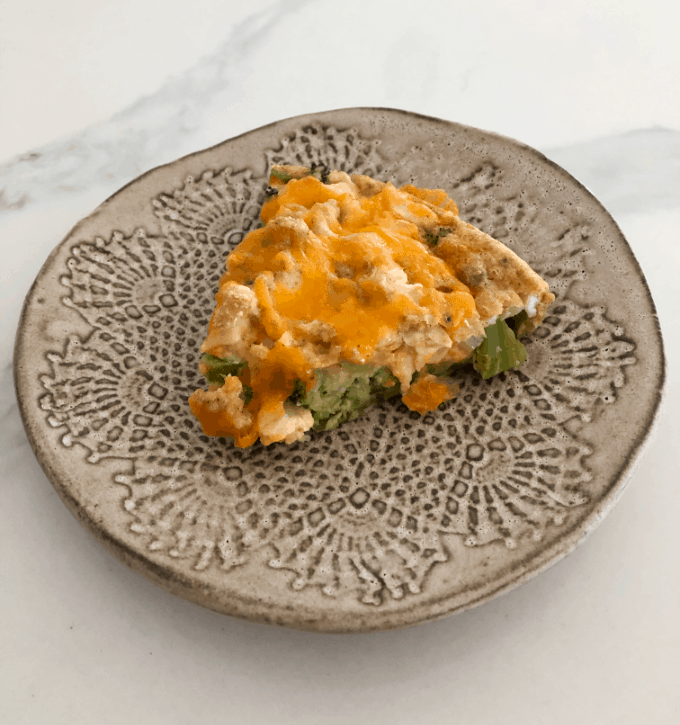 Slice of chicken broccoli pie on ceramic plate