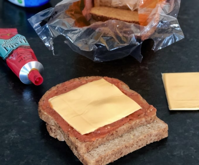 Bread, cream cheese mixture and cheese slices on kitchen counter.