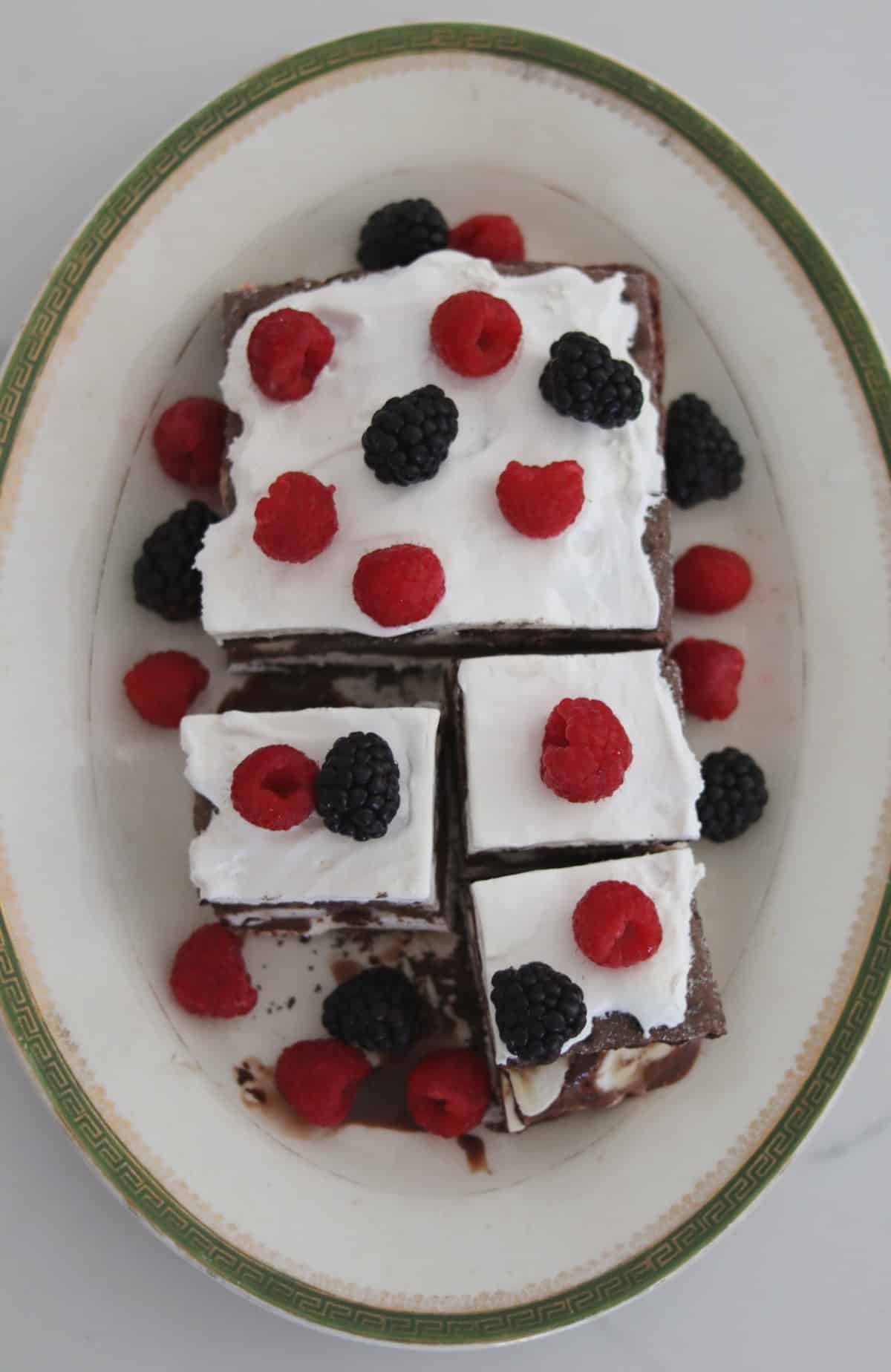 Chocolate fudge ice cream bar dessert topped with raspberries and blackberries on platter