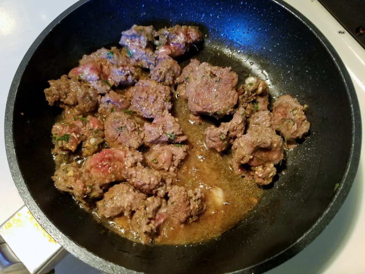 Browning ground pork and Asian spices in skillet.