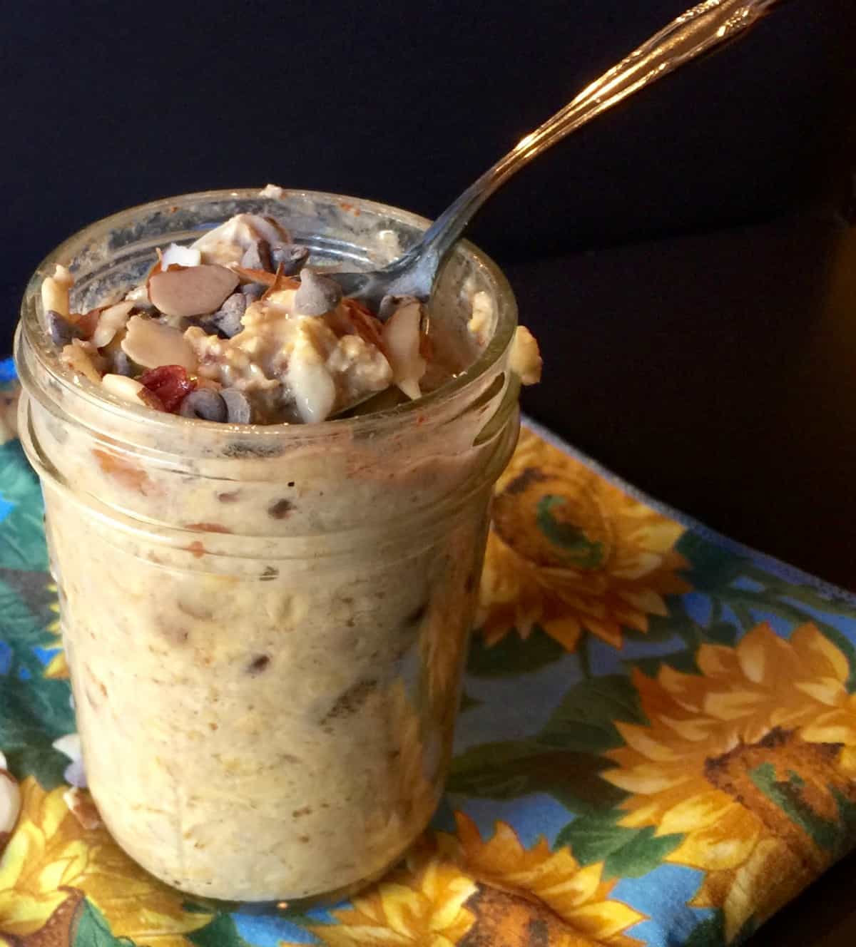 Trail Mix Overnight Oats in glass mason jar with spoon.