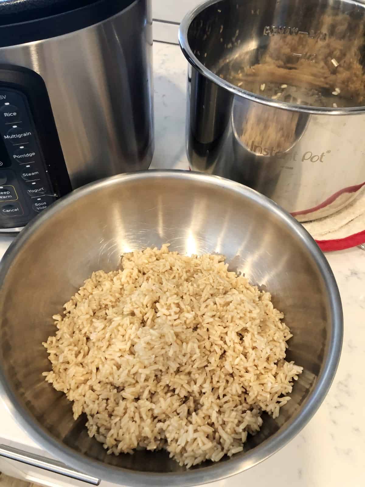Cooked brown rice in stainless bowl with Instant Pot in the background.