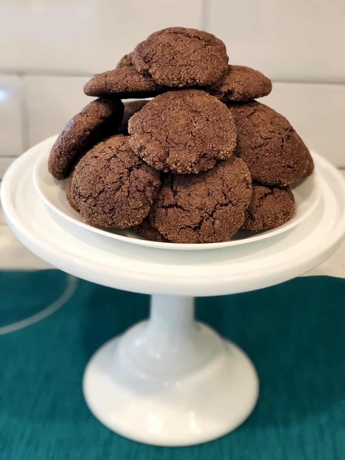Chocolate cake mix cookies stacked on white dessert stand.
