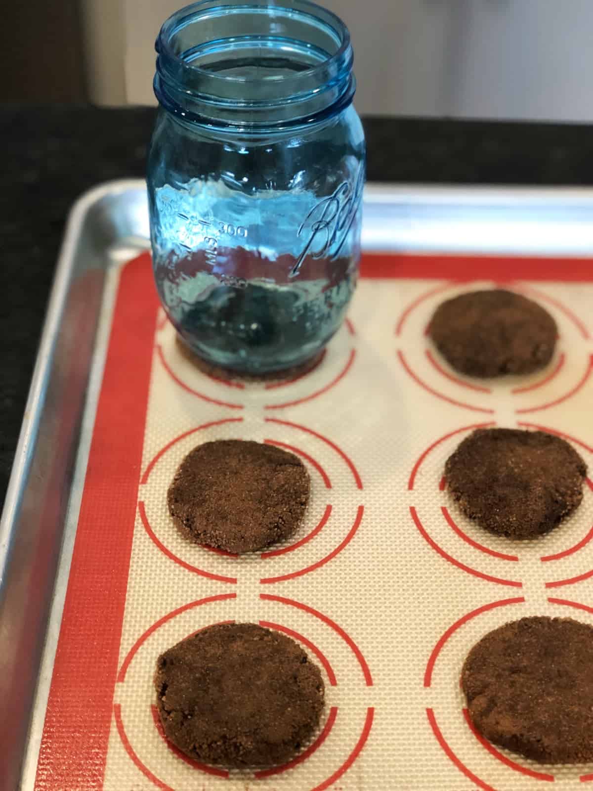 Flatten cookie dough balls on cooke sheet with mason jar.