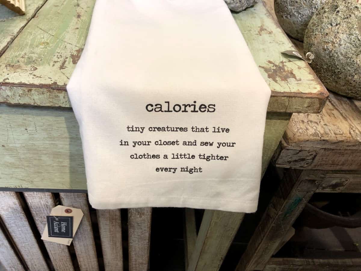 Table linen with saying about calories and weathered green table.