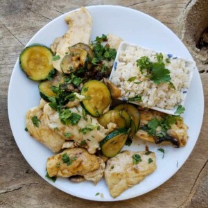 white plate with mushroom chicken zucchini stirfry shot from above