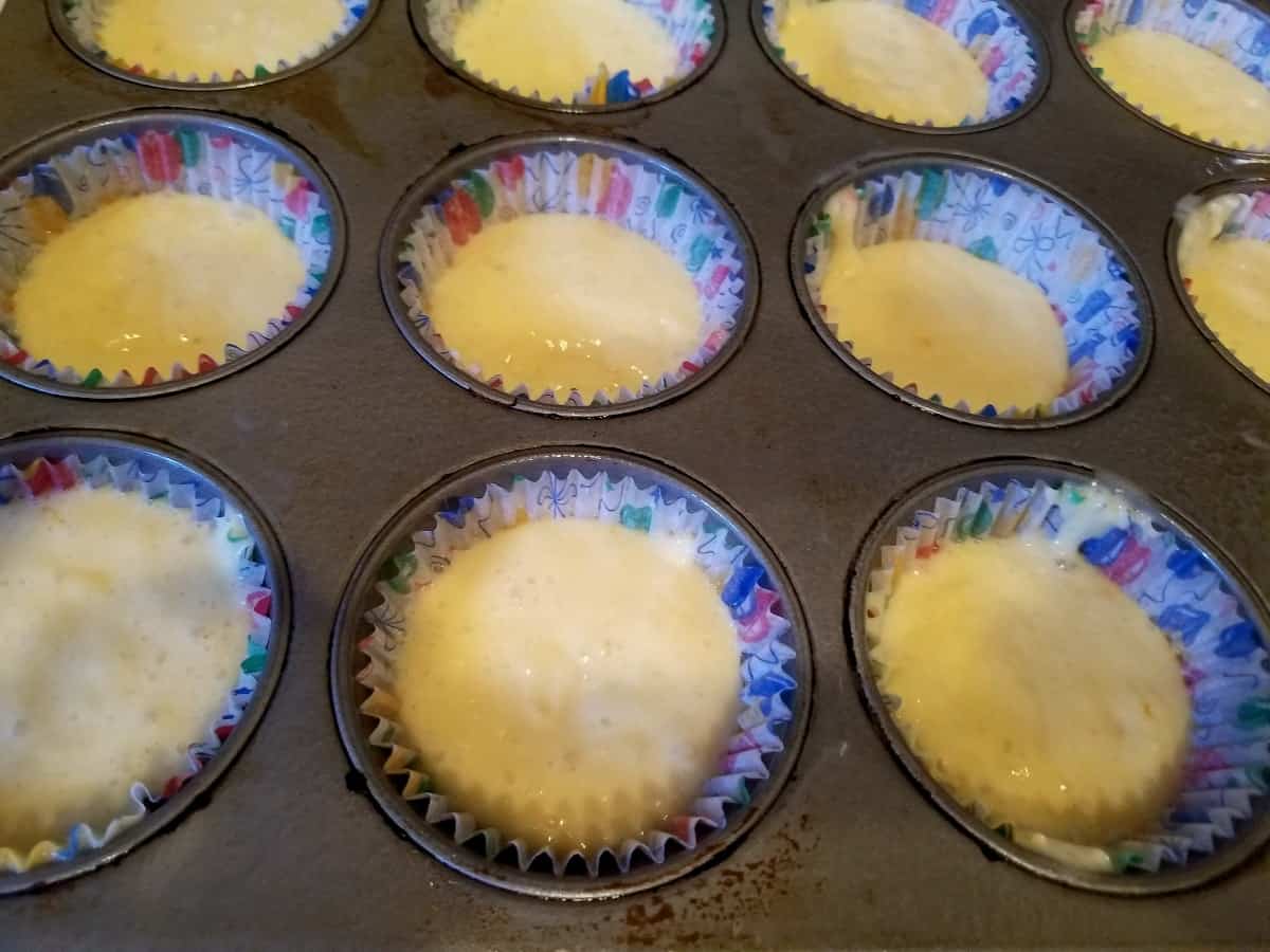 Uncooked 2-ingredient cake mix cupcakes in pan with paper cupcake liners.