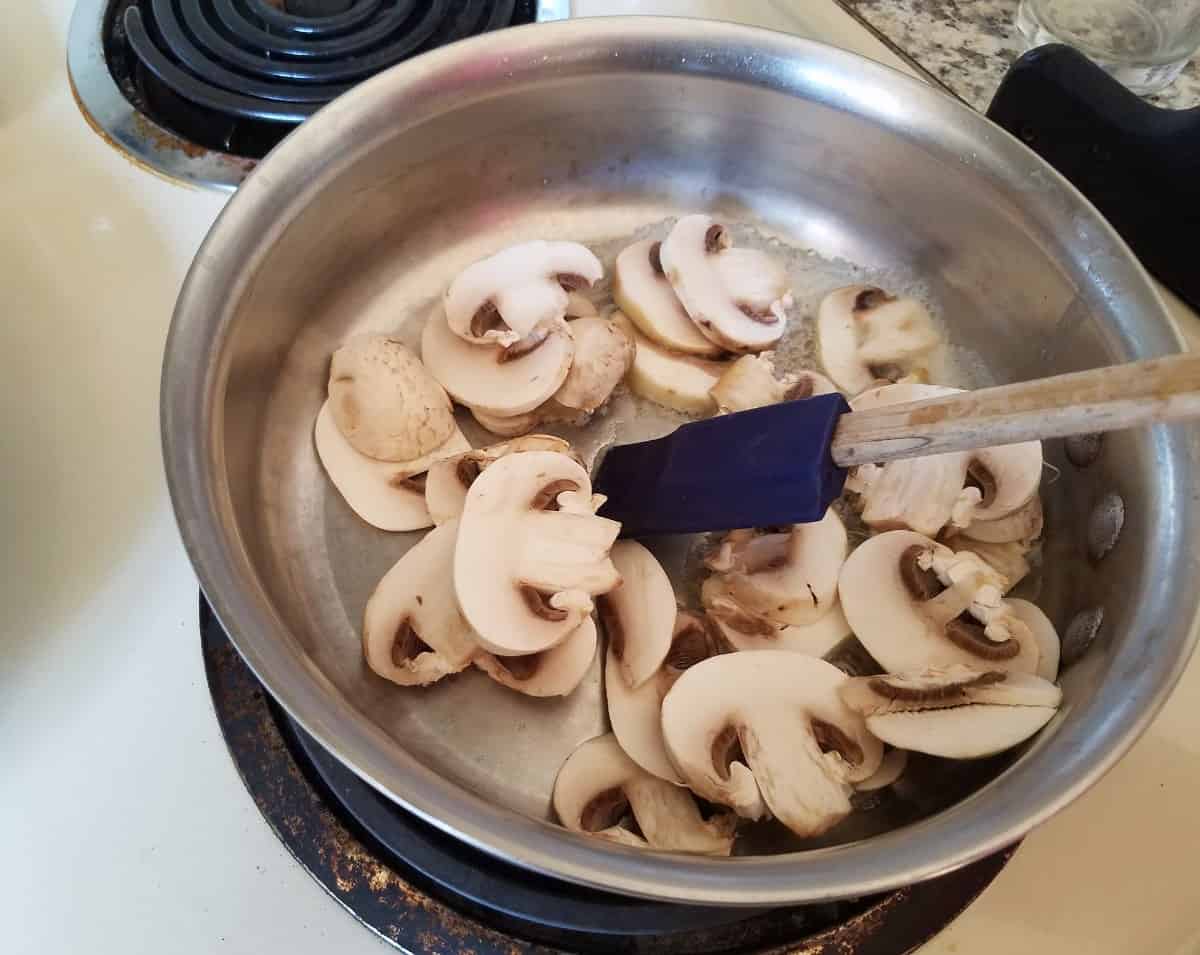 Sauteeing fresh mushrooms on stovetop.