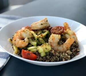 White bowl with quinoa topped with spicy shrimp