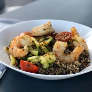 White bowl with quinoa topped with spicy shrimp