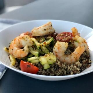 White bowl with quinoa topped with spicy shrimp