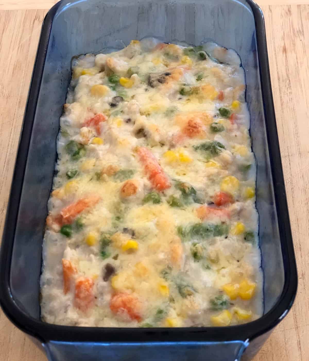 Baked turkey cheeseburger pie in blue glass loaf pan.