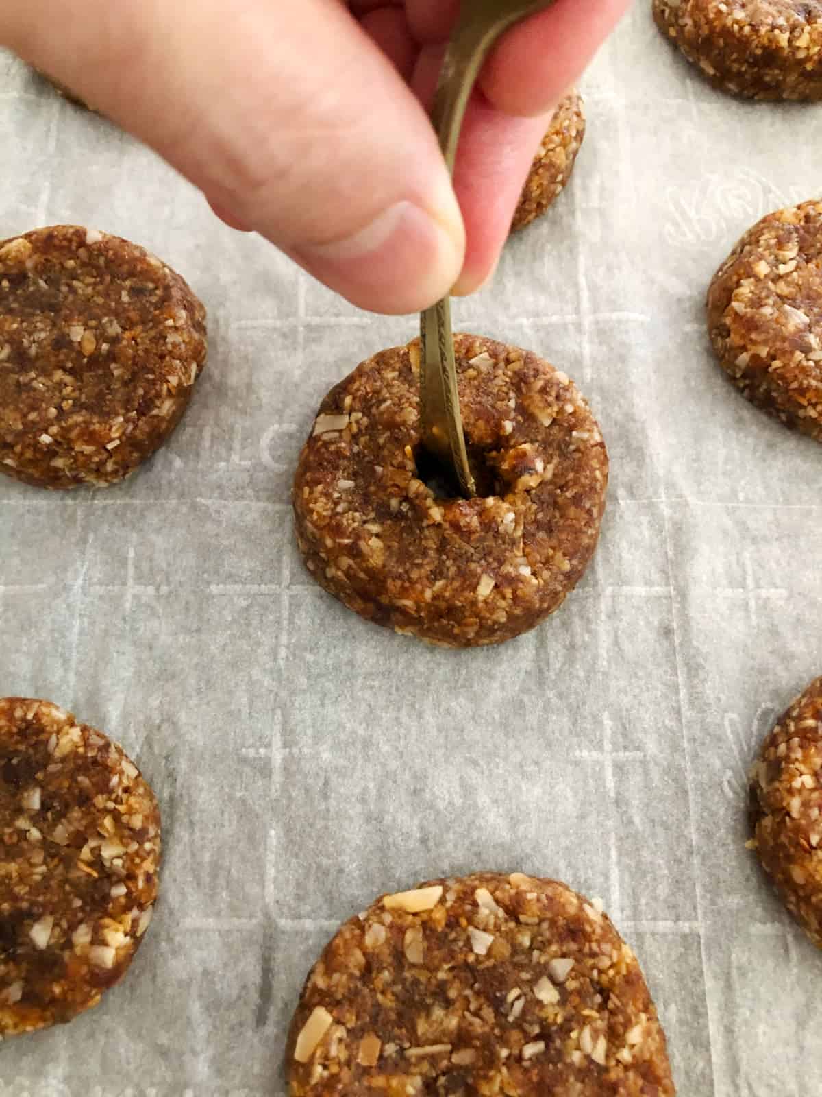 Poking holes in center of Samoas cookies with end of small spoon.