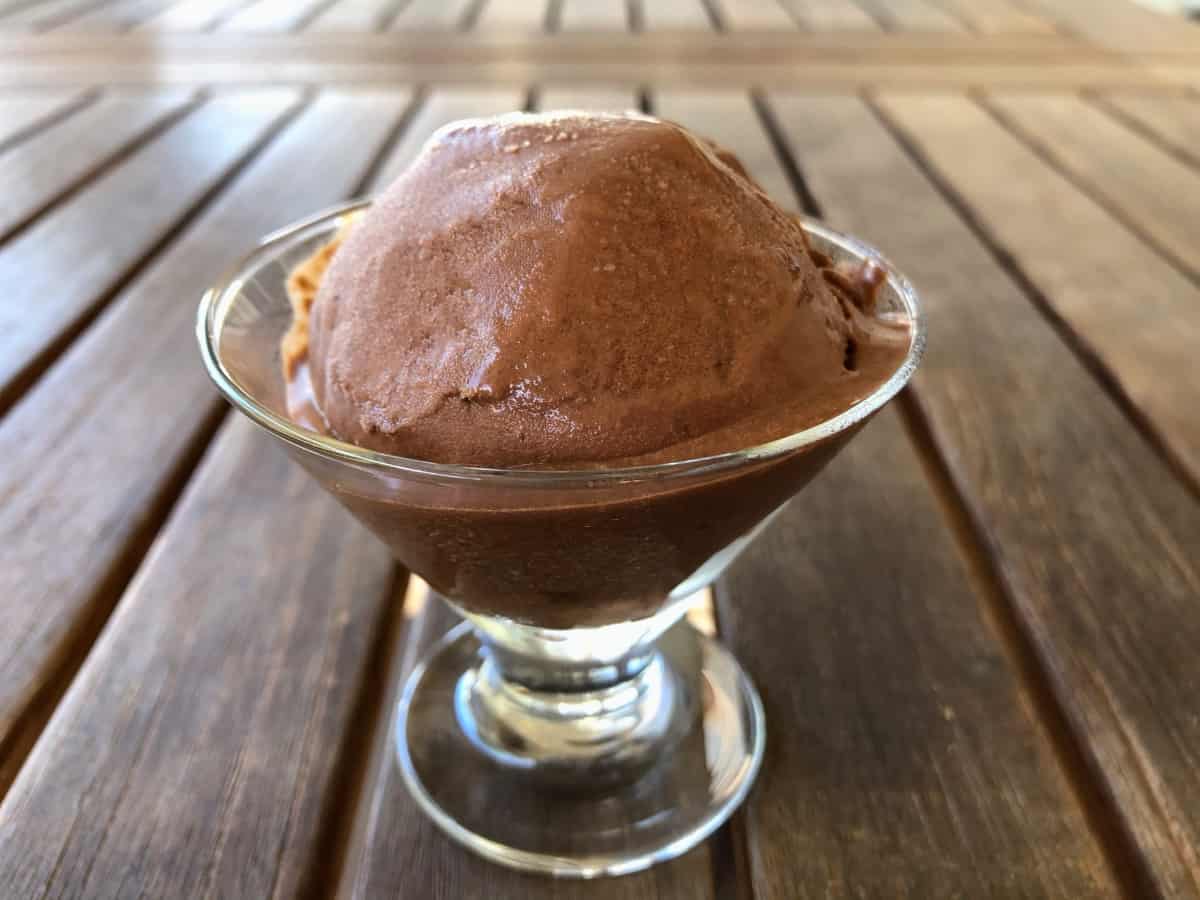 Chocolate gelato in dessert glass on wooden table.