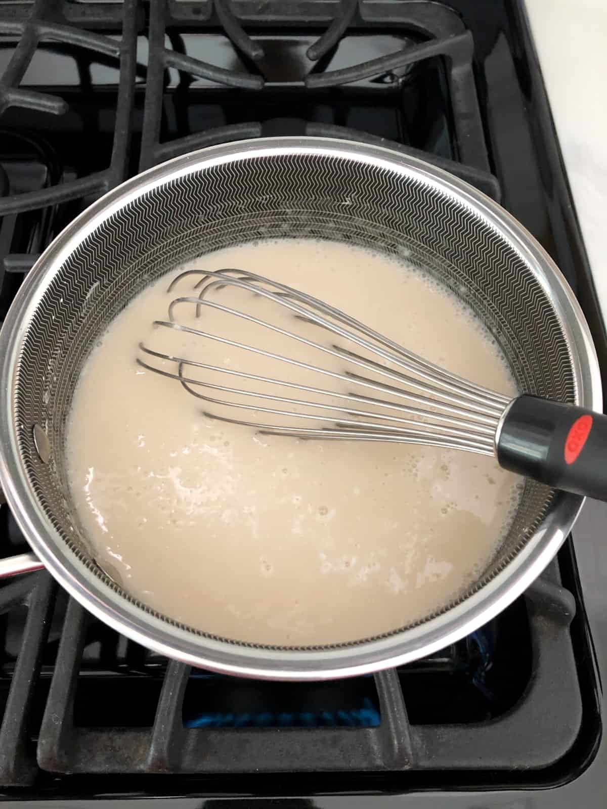 Whisking lite coconut milk, agave nectar and cornstarch in saucepan on stove.