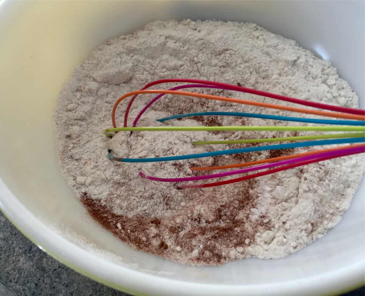 Whisking oats, protein powder, baking powder and spices in mixing bowl.