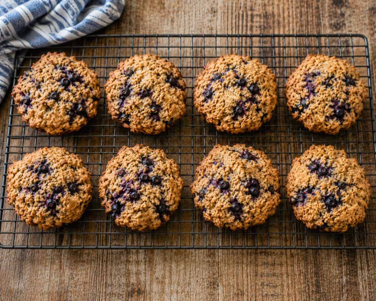 Fresh baked blueberry bran muffin tops cooling on wire rack.