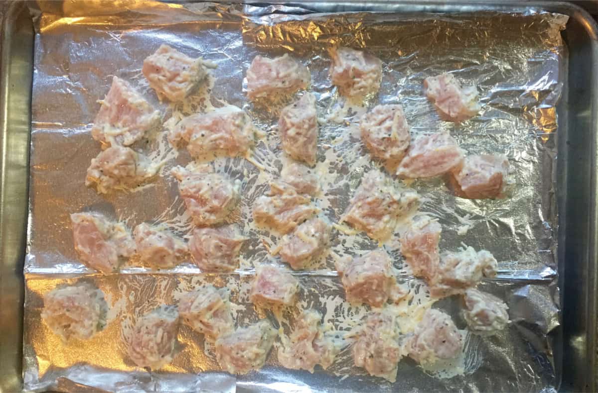 Ready to bake creamy ranch chicken bites on foil-lined baking pan.
