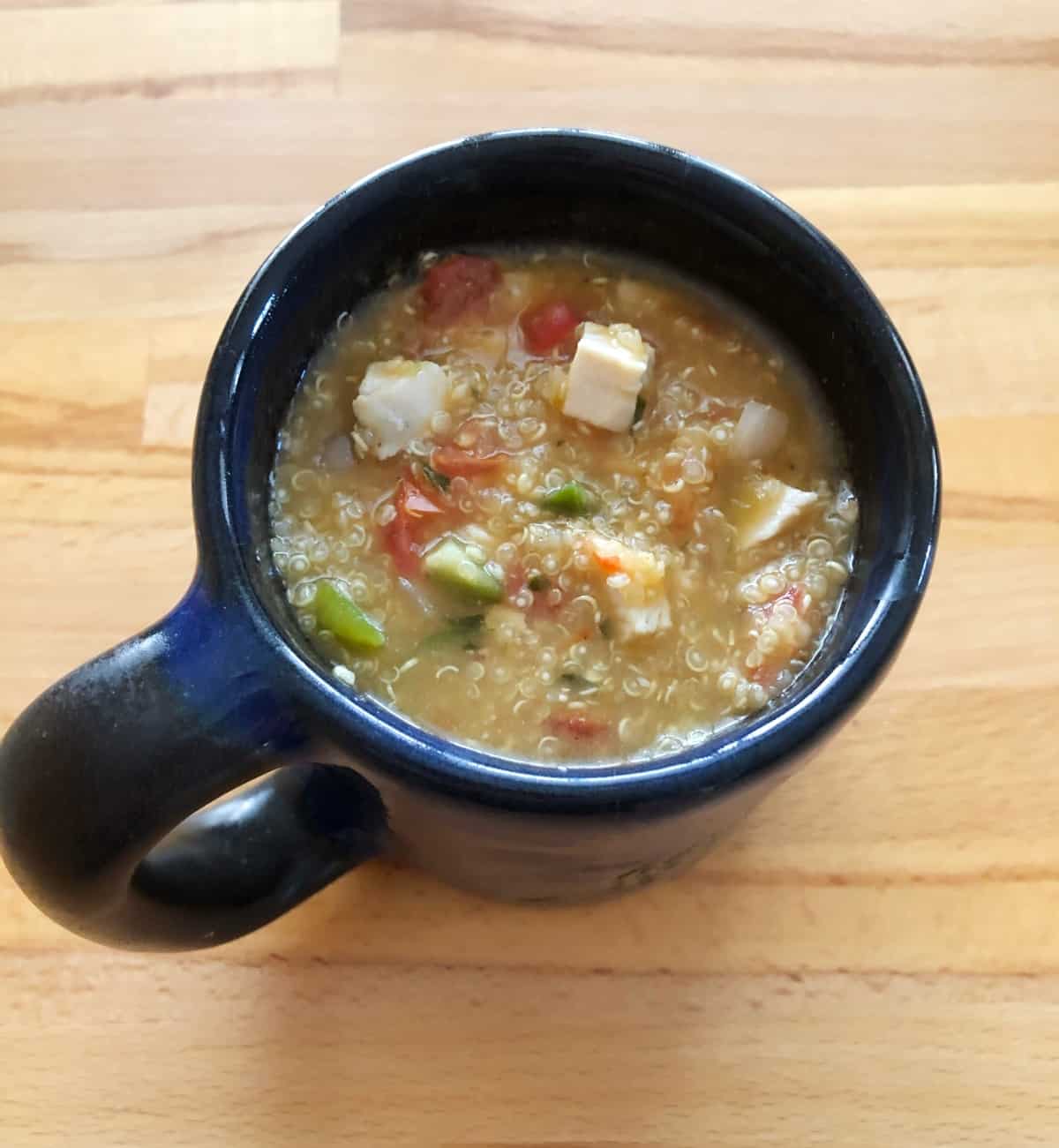 15-minute soup with quinoa, chicken and pico de gallo salsa in blue mug.