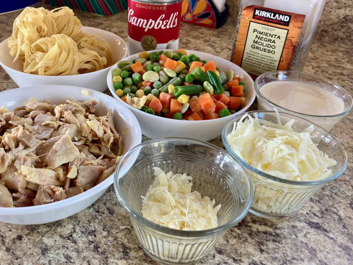 can of condensed cream of chicken soup, egg noodles, mixed vegetables, chopped chicken, grated parmesan cheese, shredded cheddar cheese, ground black pepper