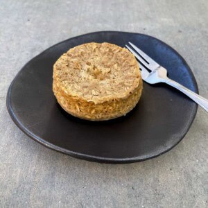 oatmeal raisin mug muffin on a brown pottery plate with fork