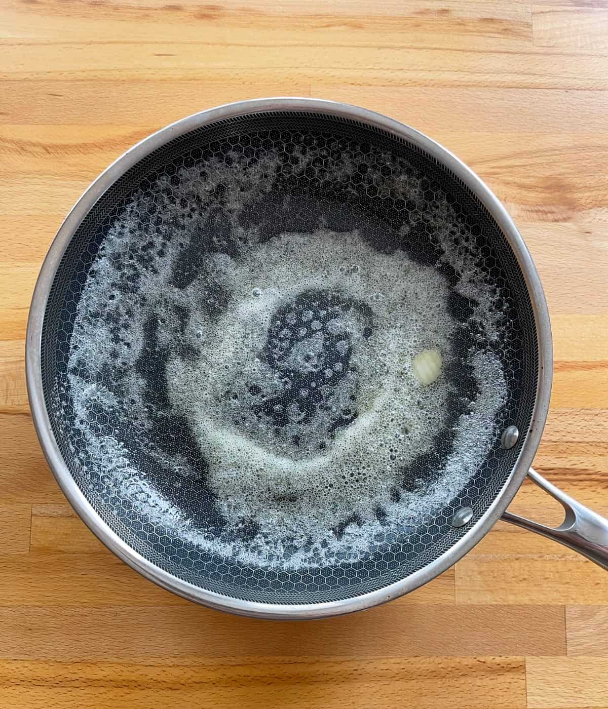 Melted butter in heated skillet.