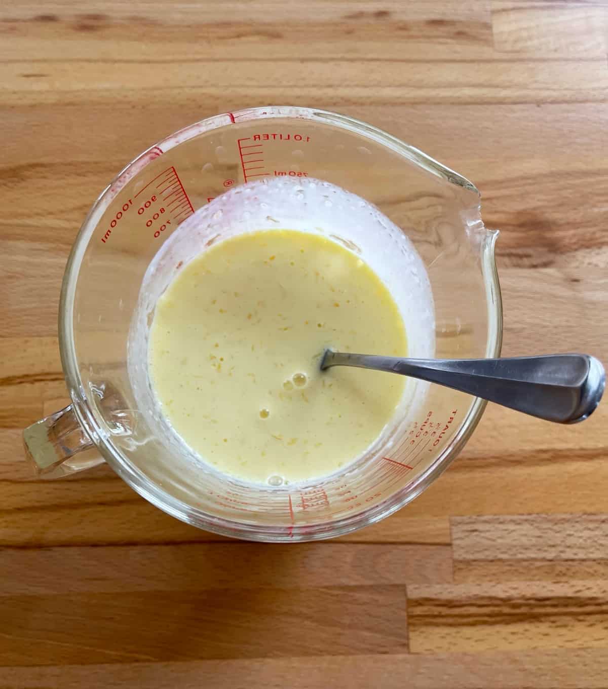 Mixing egg yolks, melted butter and buttermilk in glass measuring cup.
