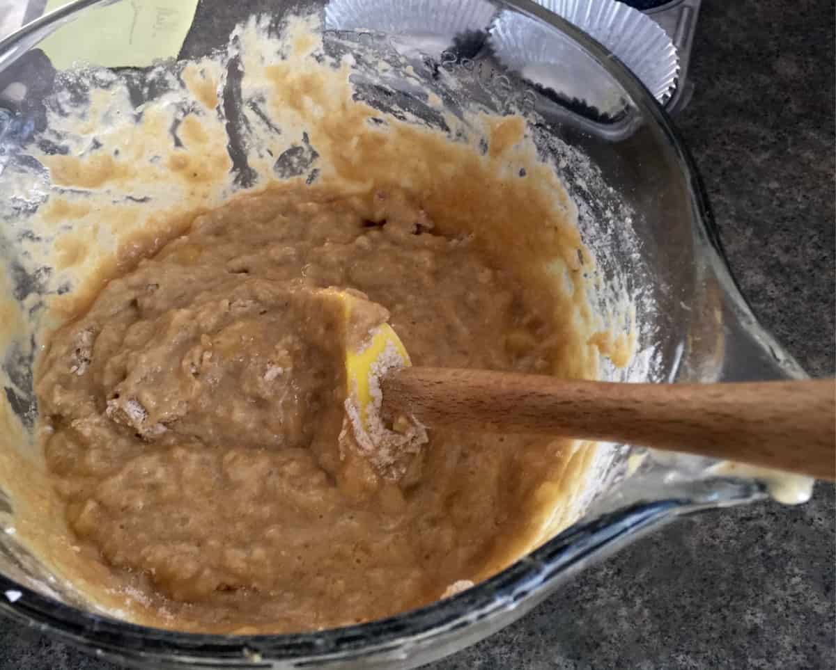 Stirring Kodiak Cakes Mix into the wet ingredients with a spatula.