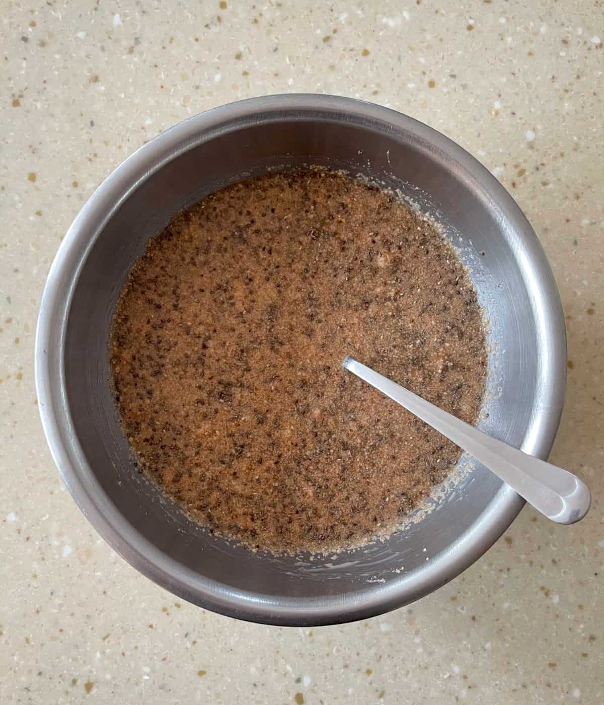Mixing cappuccino chia seed pudding in mixing bowl with spoon.