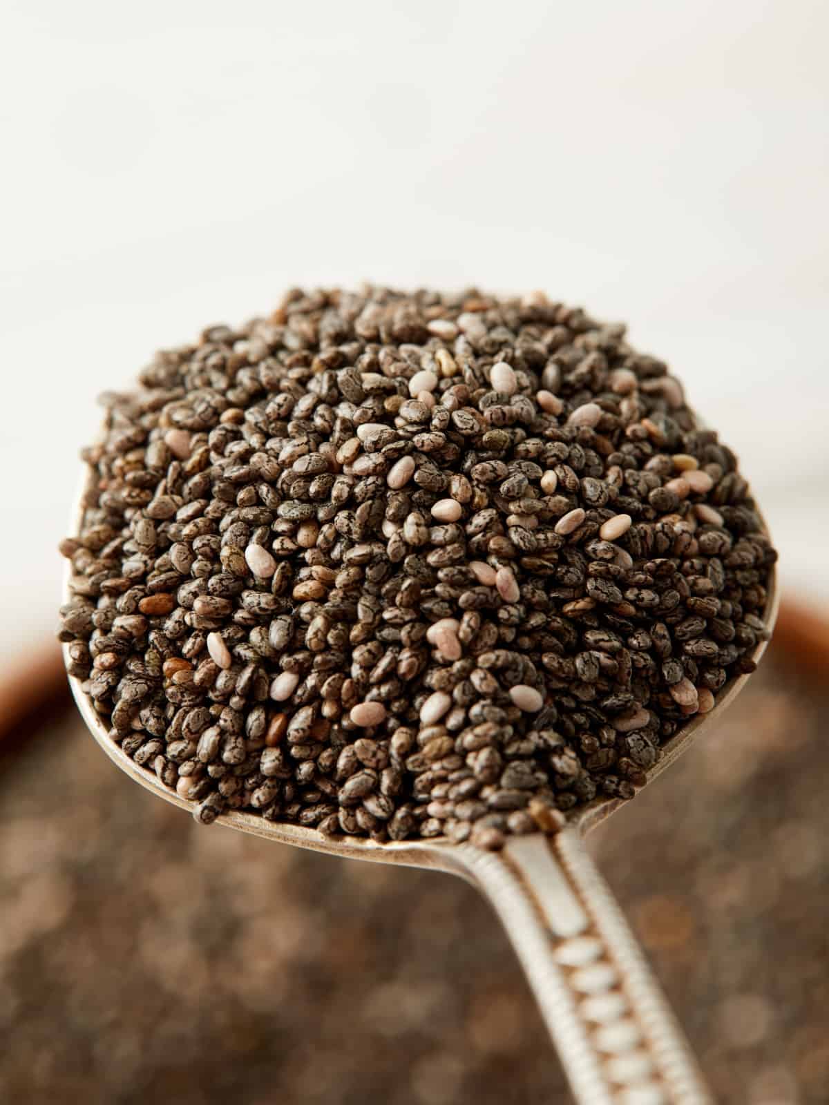 Black chia seeds on spoon up close.