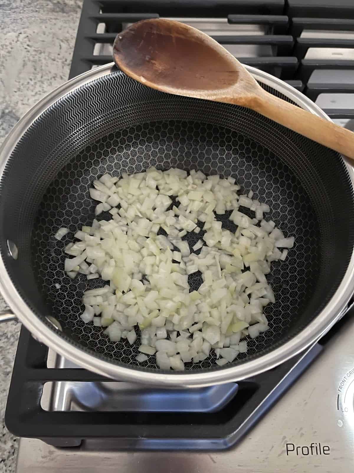 Sauteeing onions in saucepan on stovetop.