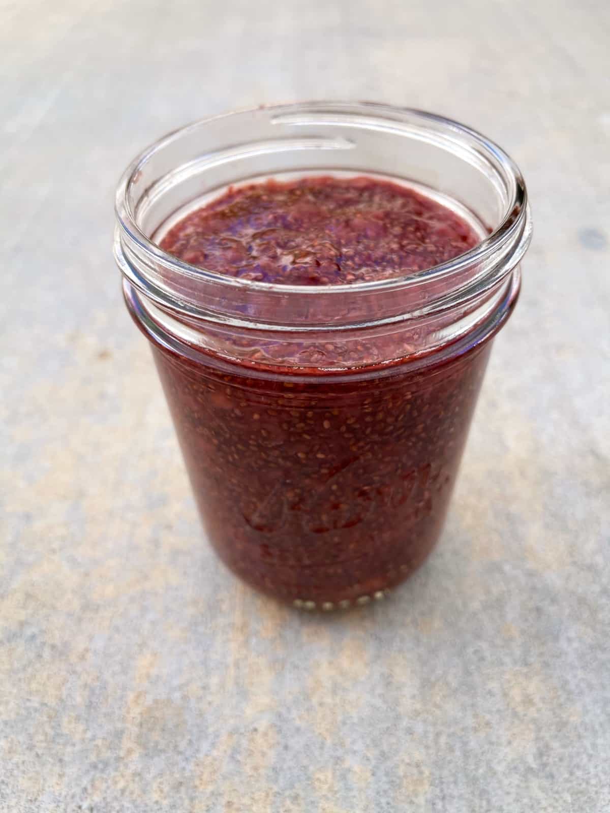 Strawberry chia seed jam in glass jar without lid.