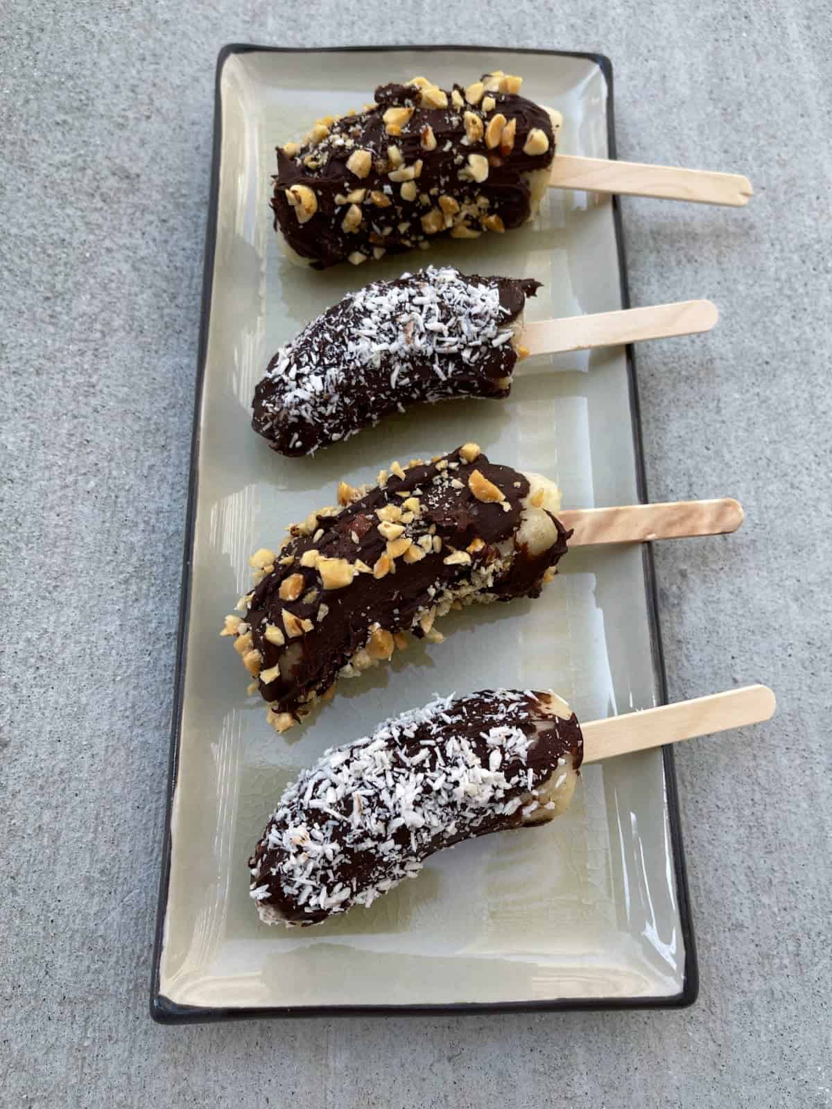 Frozen Chocolate-Dipped Bananas sprinkled with shredded coconut and chopped peanuts.