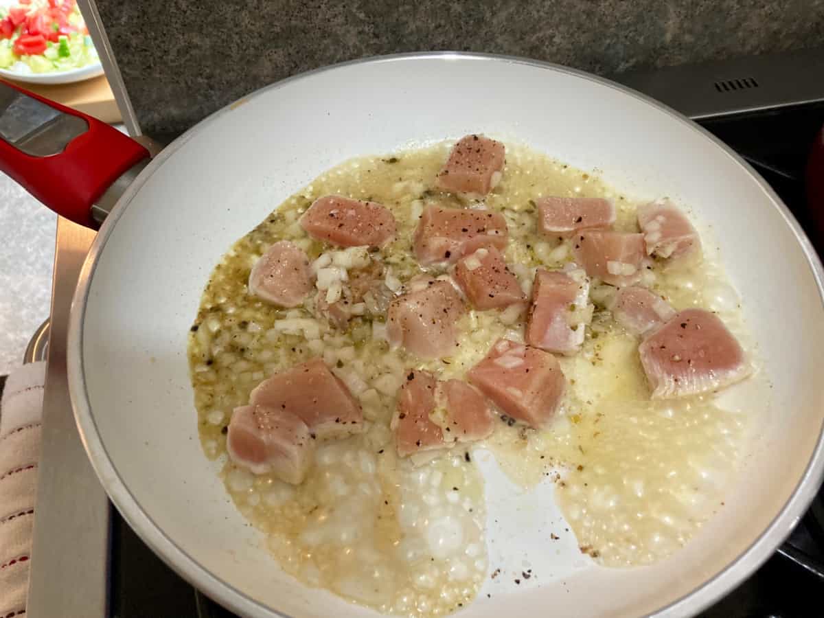Cooking chicken breast pieces in skillet.