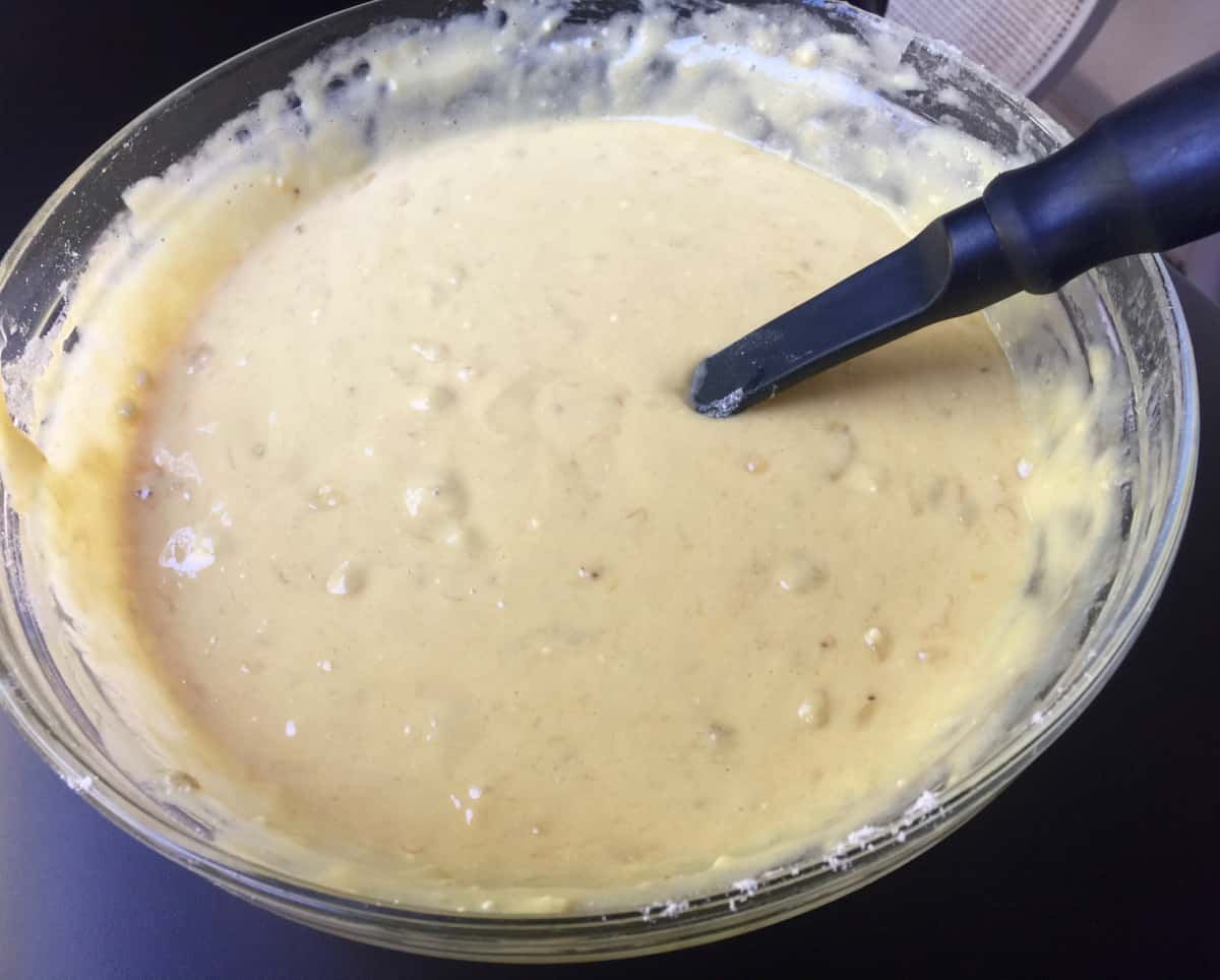 Mixing cake mix, eggs and ripe mashed bananas in mixing bowl.