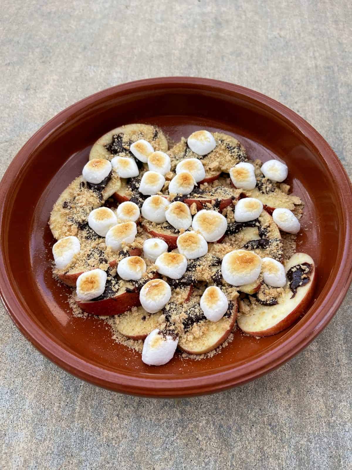 Terra cotta plate with apple s'mores nachos.