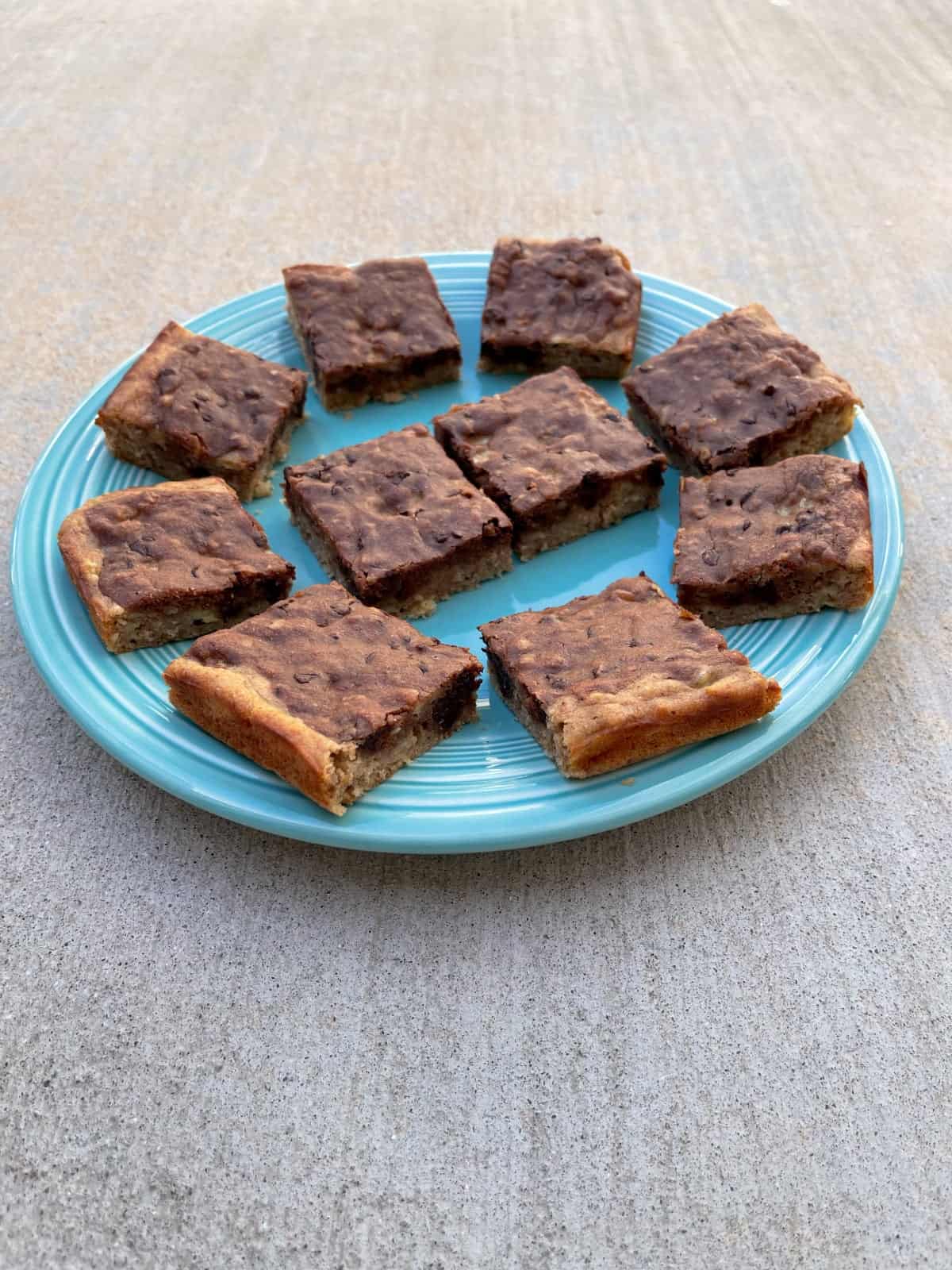 Banana bread brownies on large green plate.