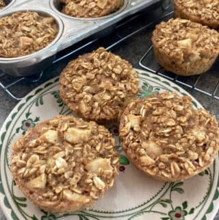 3 individual apple baked oatmeal muffin cups on patterned plate with muffin tin in background