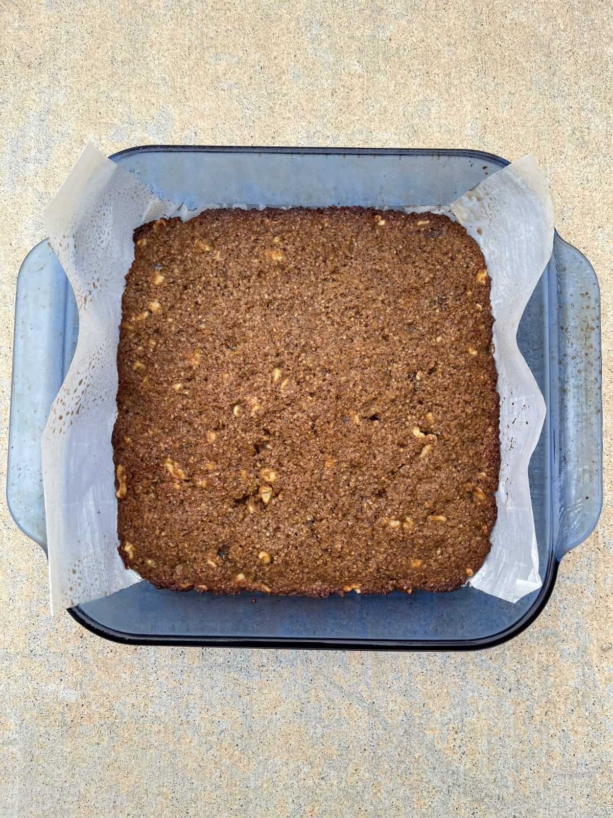 Fresh baked flourless espresso wheat germ blondies in parchment lined baking dish.