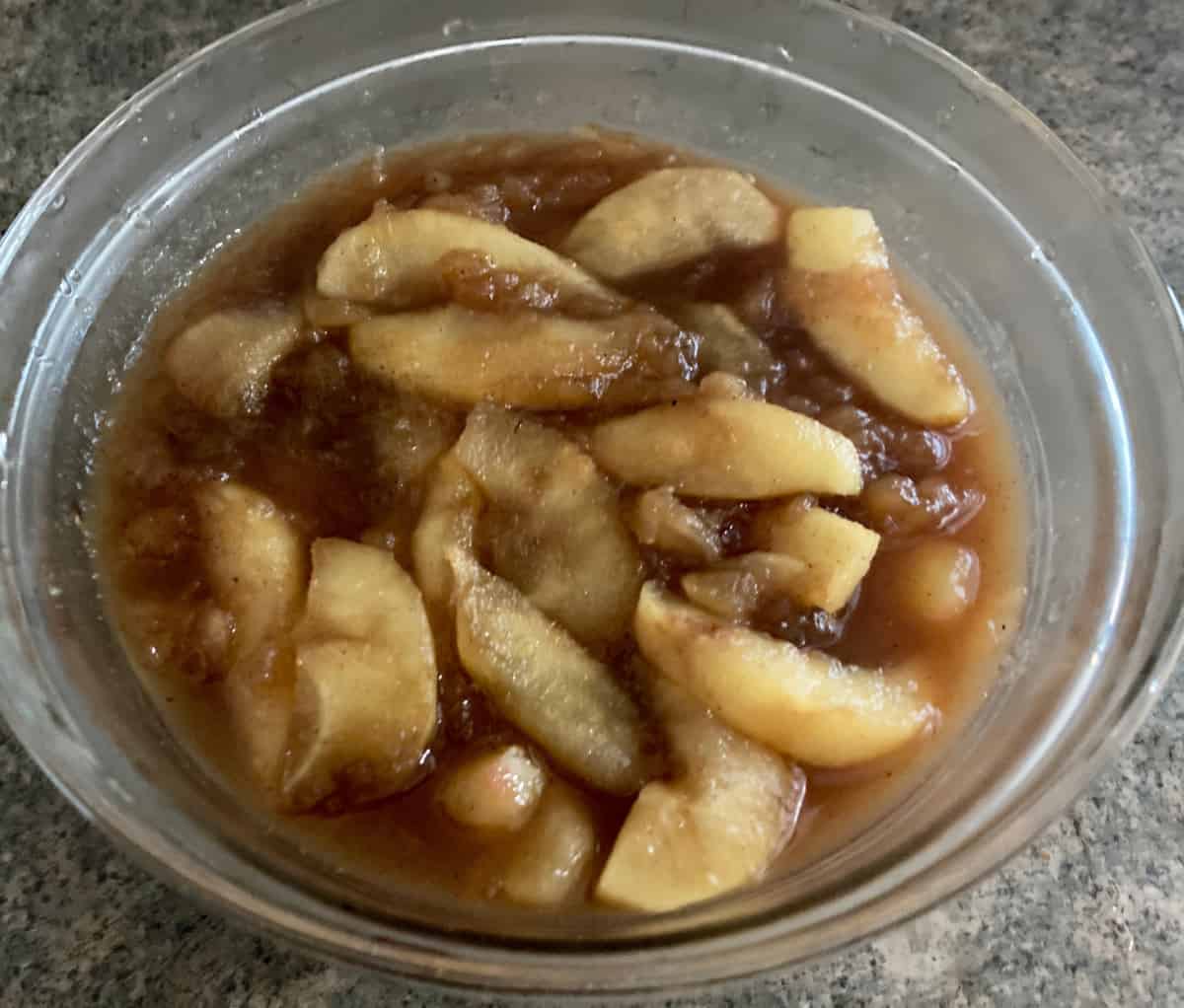 Cinnamon Apple Stir-Fry in glass bowl on counter.