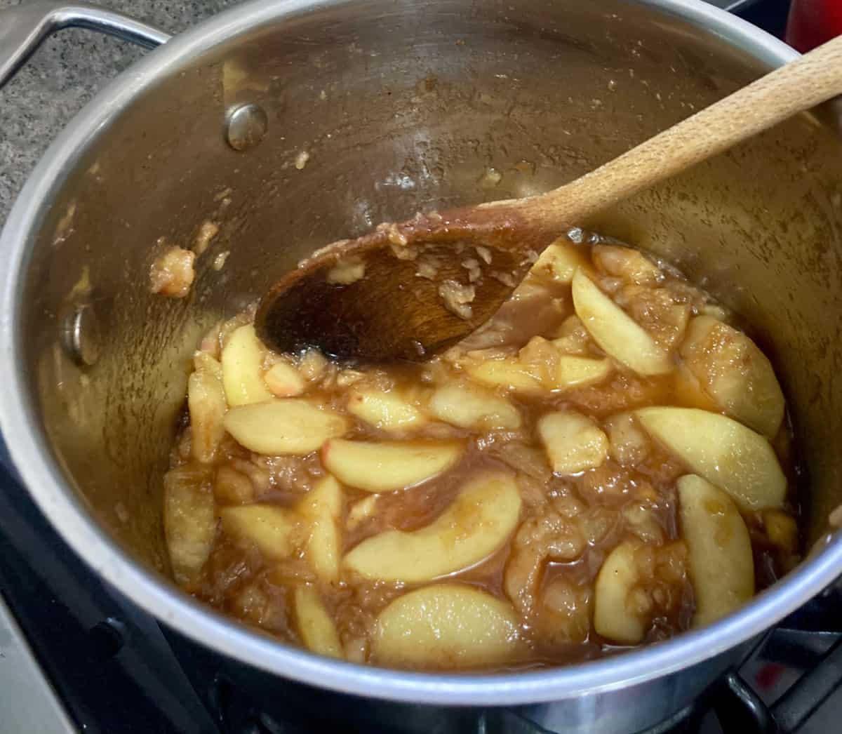 Cooking cinnamon apples with maple syrup and vanilla.