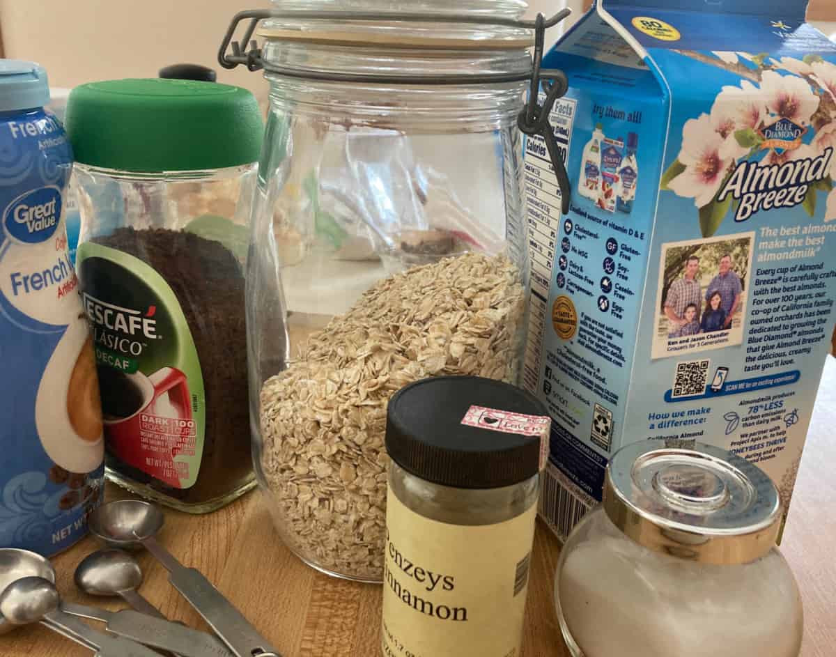 Ingredients for oatmeal including almond milk, cinnamon, rolled oats, instant coffee and French vanilla coffee creamer.