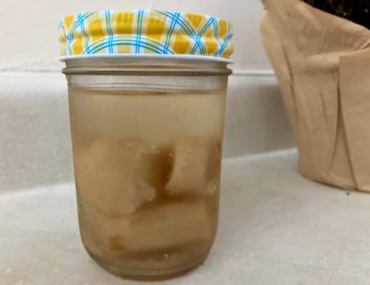 Fresh ginger root in small glass jar.